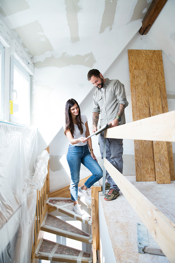 restoration contractor inspecting storm damaged home with homeowner